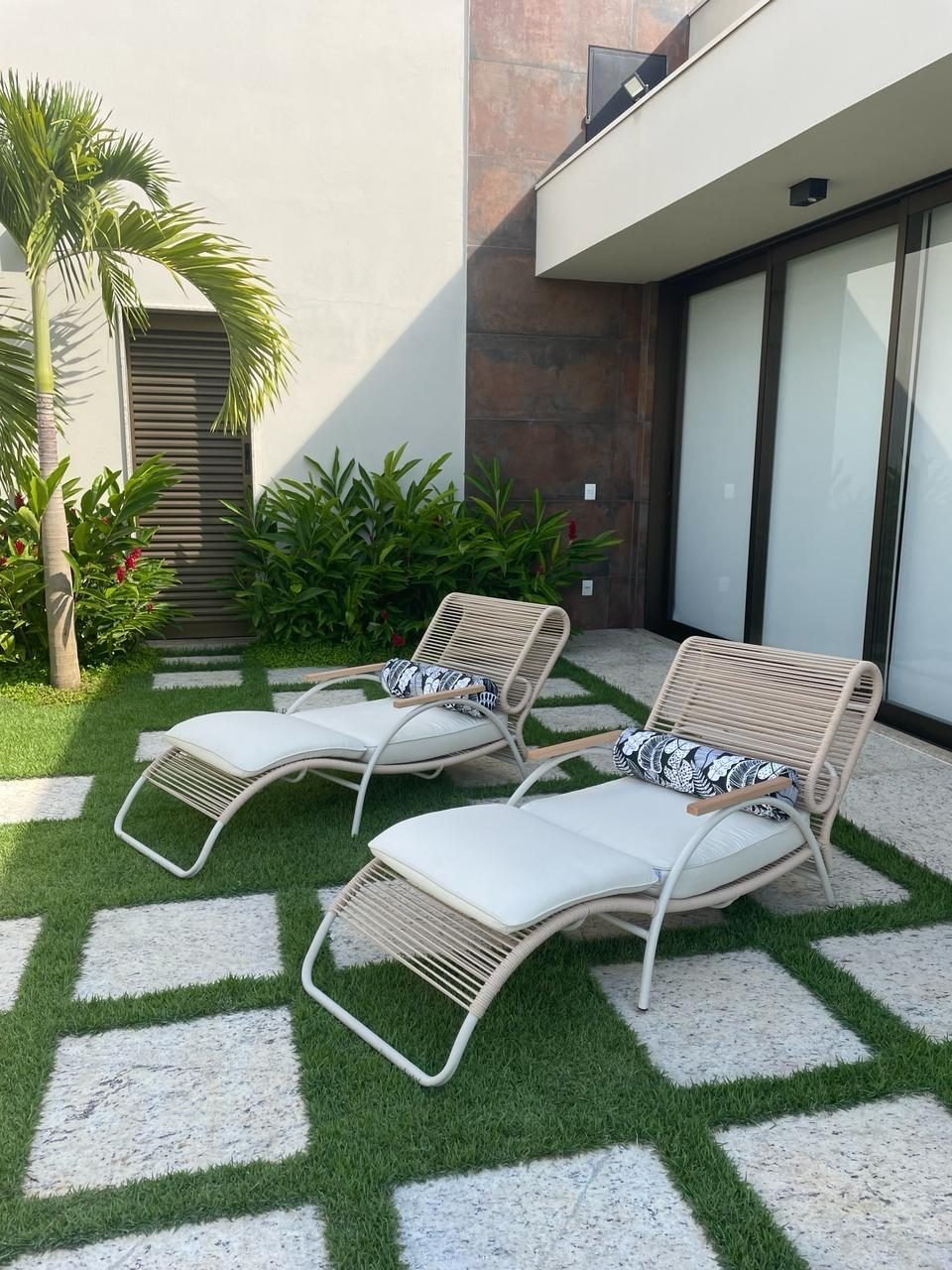 Área externa com espreguiçadeiras e jardim
